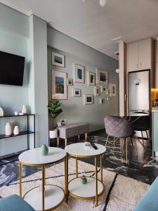uma sala de estar com duas mesas e uma televisão em Olivia Apartment-Private parking em Chalkida