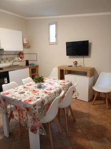 uma sala de jantar com uma mesa e cadeiras e uma televisão em Per chi ama mare e montagna! em Camaiore