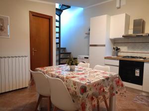 uma cozinha com uma mesa e cadeiras com uma toalha de mesa em Per chi ama mare e montagna! em Camaiore