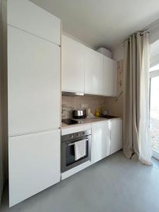 a kitchen with white cabinets and a stove at Casa Alta T0 in Castelo de Vide