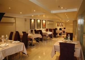 a restaurant with tables and chairs with white table cloth at Hotel Palm Do'r Near New Delhi Railway Station in New Delhi