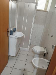 ein weißes Bad mit einem WC und einem Waschbecken in der Unterkunft b&b Sirianni in SantʼEufemia Lamezia