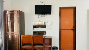 Habitación con TV y escritorio con silla. en Hotel Nepal Inn Sauraha, en Sauraha