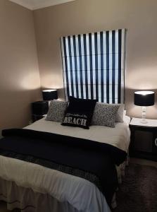 a bedroom with a large bed with a headboard at Blombos 10 in Stilbaai