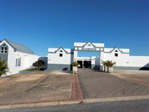 a large white building with a sign on it at Blombos 10 in Stilbaai