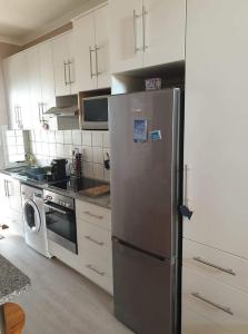 uma cozinha com um frigorífico de aço inoxidável e uma máquina de lavar louça em Blombos 10 em Stilbaai