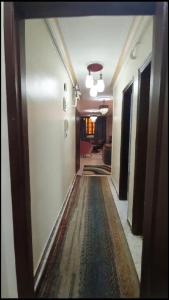 un corridoio che conduce a una camera con un tappeto sul pavimento di شقة مفروشة مميزة جدا a Mît Khamîs