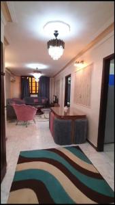 a living room with a table and a couch at شقة مفروشة مميزة جدا in Mît Khamîs