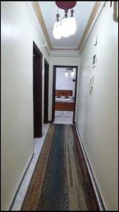 a hallway with a rug on the floor of a room at شقة مفروشة مميزة جدا in Mît Khamîs