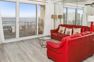 um sofá vermelho e uma cadeira num quarto com janelas em Sterling Shores 918 condo em Destin