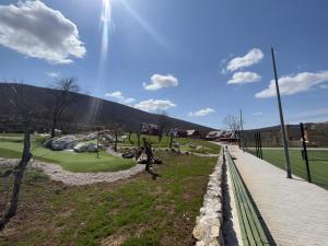 a view of a golf course with the sun in the sky at Plitvice Village in Korenica