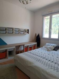 Schlafzimmer mit einem Bett, einem Schreibtisch und einem Fenster in der Unterkunft Villa aiguës marines in Pérols