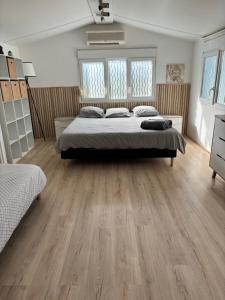 拉西約塔的住宿－Chalet nature proche plage，一间卧室设有一张大床,铺有木地板。
