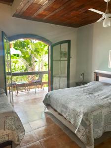 a bedroom with a bed and a patio with a table at HOSTEL DAS ESTRELAS in Areal