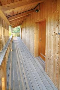 a porch of a wooden cabin with a wooden walkway at Zlatý apartmán v soukromí Malá Skála Český Ráj in Koberovy