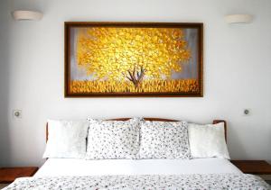 a painting of a yellow tree above a bed at Zlatý apartmán v soukromí Malá Skála Český Ráj in Koberovy