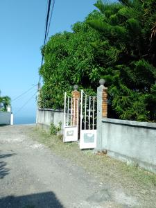 a gate to a house with the ocean behind it at STUDIO / HAUT DE VILLA / / VUE SUR MER / SALONORAT in Bouillante