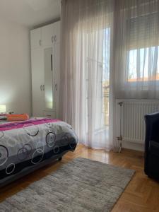 um quarto com uma cama e uma grande janela em Jana Royal Zarkovo em Bele Vode
