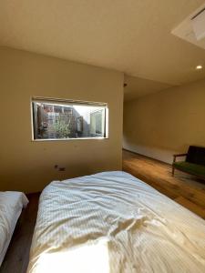 um quarto com uma cama grande e uma janela em etoile inn sumoto - Vacation STAY 49252v em Sumoto