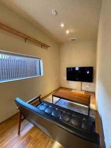 a living room with a couch and a flat screen tv at etoile inn sumoto - Vacation STAY 49252v in Sumoto