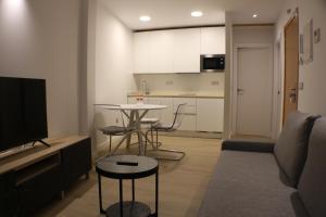 a living room with a couch and a table and a kitchen at APARTAMENTOS PICOS DE EUROPA in Santander