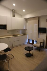 a kitchen and a living room with a table and chairs at APARTAMENTOS PICOS DE EUROPA in Santander +16 photos