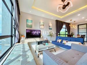 uma sala de estar com um sofá azul e uma televisão em #11 Jesselton Quay City Pads Seaview Corner em Kota Kinabalu