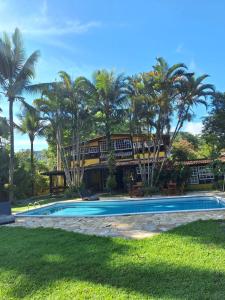 a resort with a swimming pool and palm trees at Pousada Serra da Bocaina Paraty in Paraty