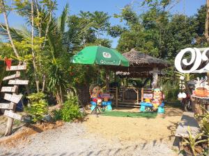 a group of dolls sitting on the beach under an umbrella at Ozone farm resort in Ban Nong Talumphuk