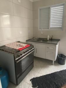 a kitchen with a stove and a sink at Casa Guarujá próx. Balsa Santos in Guarujá