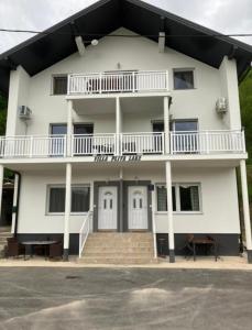 um grande edifício branco com uma varanda e escadas em Villa Pliva Lake em Jajce