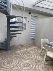 瓜魯雅的住宿－Casa Guarujá próx. Balsa Santos，一间铺有瓷砖地板的客房内的螺旋楼梯