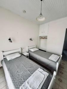 a bedroom with two beds and a lamp at Alexandros Studios Apartments in Roda