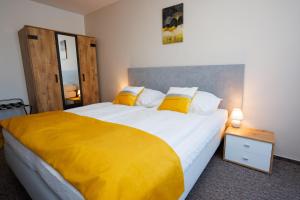 a bedroom with a large bed with a yellow blanket at Hotel FIT in Přerov