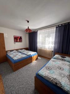 een slaapkamer met 2 bedden en een raam bij Ubytování v apartmánech pod Radhoštěm in Prostřední Bečva