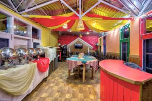 a restaurant with a table and chairs in a room at Agro Stone Cottage & Cafe in Mashobra