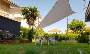 a table and two chairs in a yard with an umbrella at Casa Vacanze DaRena in Tortoreto Lido
