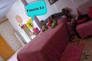 een slaapkamer met een bed met een roze sprei bij Casa Temporada à Beira da Praia in Maricá