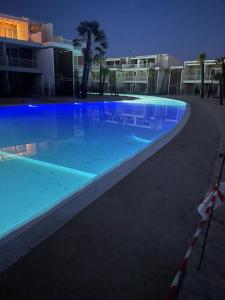 uma grande piscina à noite com edifícios ao fundo em Romantika apartment em Lido di Jesolo