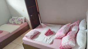 two beds in a room with pink and white pillows at HOSTEL, POUSADA e APART em PORTO SEGURRO PRAIA in Porto Seguro