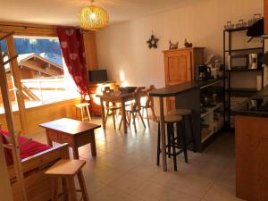 a kitchen with tables and stools in a room at Appartement Le Grand-Bornand, 2 pièces, 6 personnes - FR-1-458-197 in Le Grand-Bornand