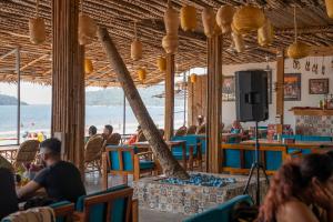 persone sedute in un ristorante con la spiaggia sullo sfondo di COCO CABANA a Palolem