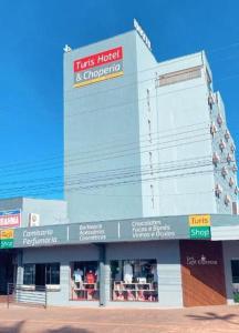 a building with a sign that reads his hotel and grocery at Turis Hotel in Dourados