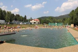 een groep mensen die zwemmen in een zwembad bij Ubytování v apartmánech pod Radhoštěm in Prostřední Bečva