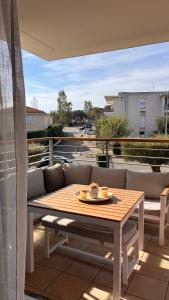 a table and a bench on a balcony at Appartement 2 chambres dans résidence avec piscine et parking in La Ciotat