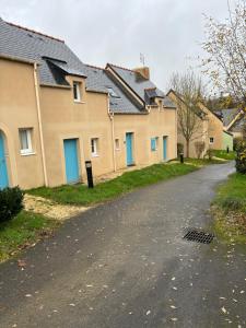 a row of houses with blue doors on a street at maison avec piscine in Le Tronchet