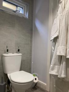 La salle de bains est pourvue de toilettes, d'une fenêtre et de serviettes. dans l'établissement Beautiful new Garden Annexe, à Ashton-in-Makerfield