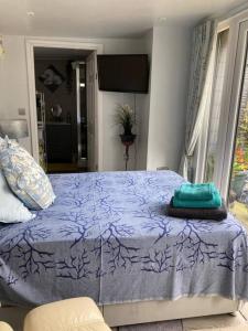 - une chambre avec un lit et une couette violette dans l'établissement Beautiful new Garden Annexe, à Ashton-in-Makerfield