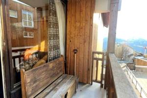 a porch with a bench on a balcony at La cabane in LʼHuez