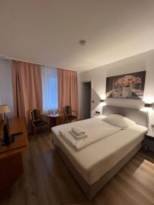 a bedroom with a bed and a table and chairs at Hotel 9-enhof in Wuppertal